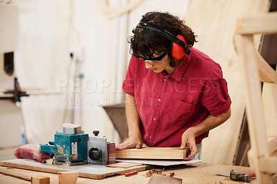 Buy stock photo Shot of a woman working with wood in a furniture manufacturing workshop