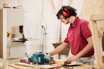 Buy stock photo Shot of a woman working with wood in a furniture manufacturing workshop