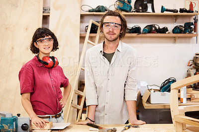 Buy stock photo Shot of two people working with wood in a furniture manufacturing workshop