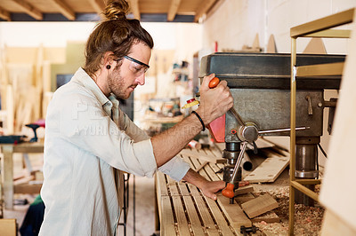 Buy stock photo Shot of a man working with wood in a furniture manufacturing workshop