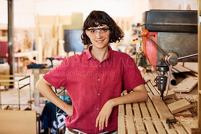 Buy stock photo Shot of a woman working with wood in a furniture manufacturing workshop