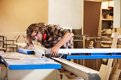 Buy stock photo Shot of a man working with wood in a furniture manufacturing workshop