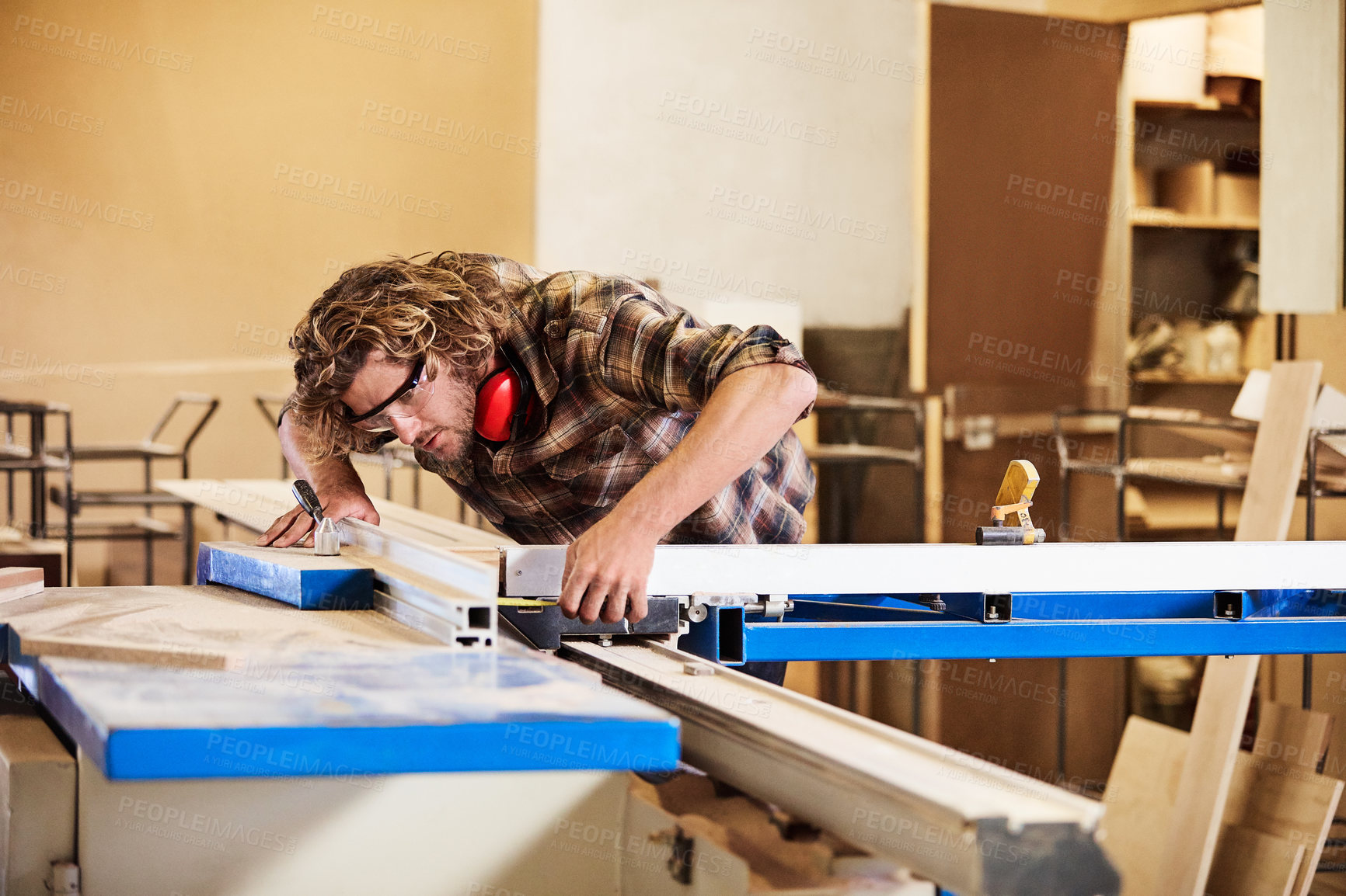 Buy stock photo Shot of a man working with wood in a furniture manufacturing workshop