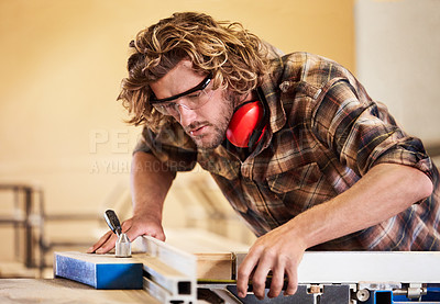 Buy stock photo Shot of a man working with wood in a furniture manufacturing workshop
