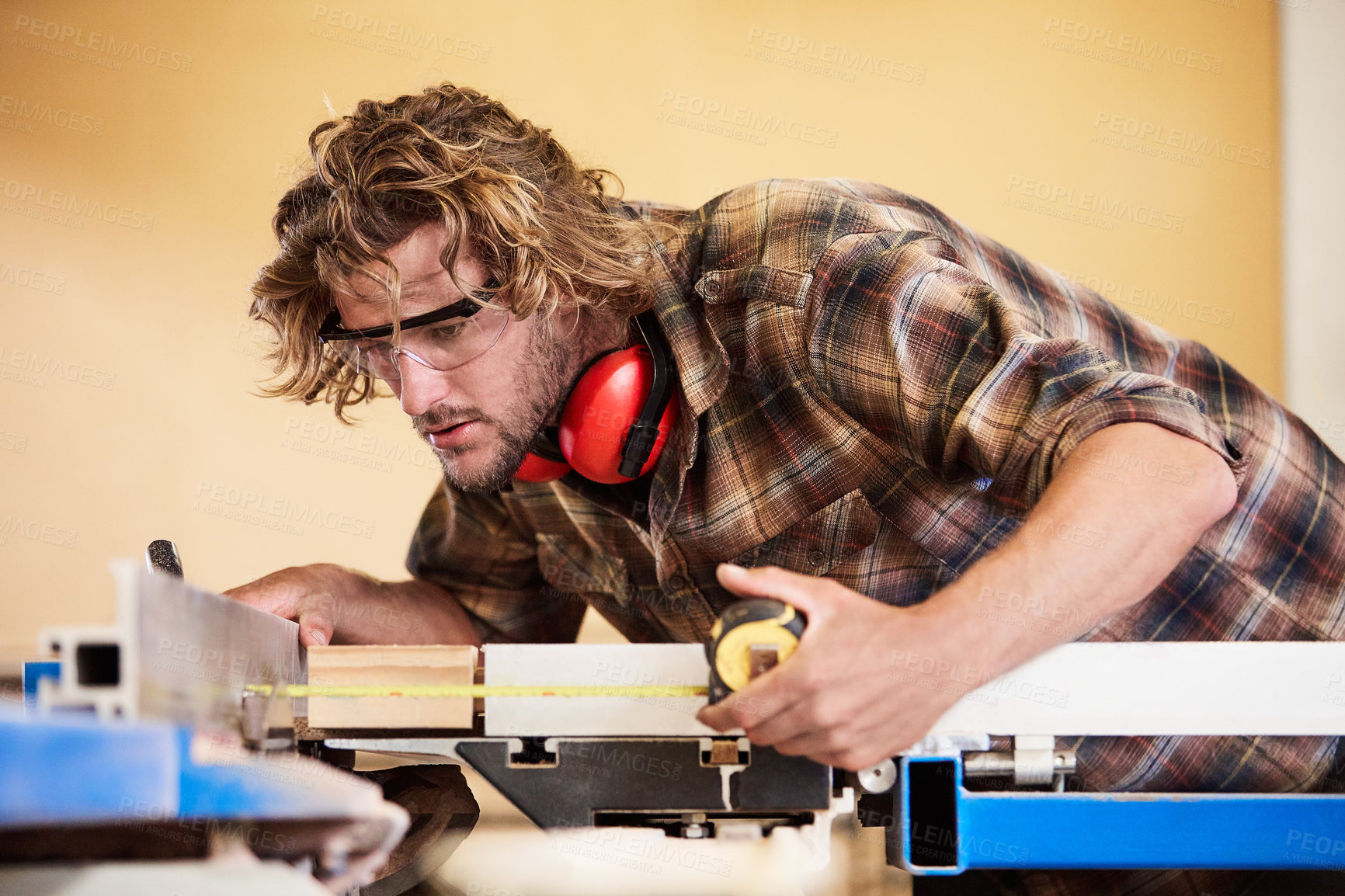 Buy stock photo Workshop, carpenter and man with tape measure, wood and inspection for woodworking accuracy. Carpentry, ppe and person with measurement for furniture repair, timber production and lumber project