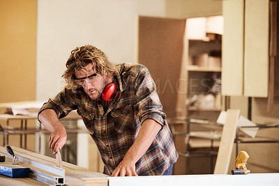 Buy stock photo Shot of a man working with wood in a furniture manufacturing workshop