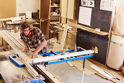 Buy stock photo Shot of a man working with wood in a furniture manufacturing workshop