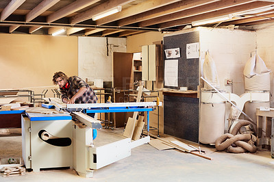 Buy stock photo Shot of a man working with wood in a furniture manufacturing workshop