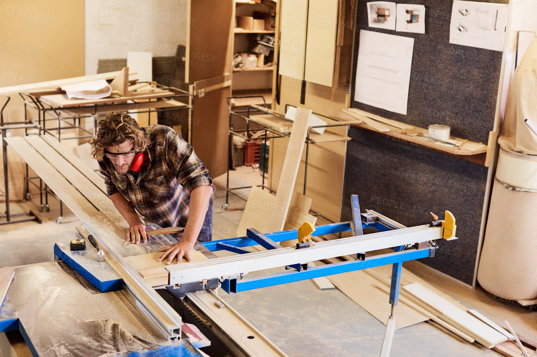 Buy stock photo Woodworker, cutting and man with safety glasses in workshop, craftsmanship and furniture production. Manufacturing, saw and person with woodworking equipment, above and carpenter with project