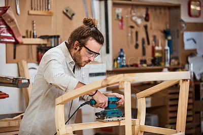 Buy stock photo Shot of a man working with wood in a furniture manufacturing workshop