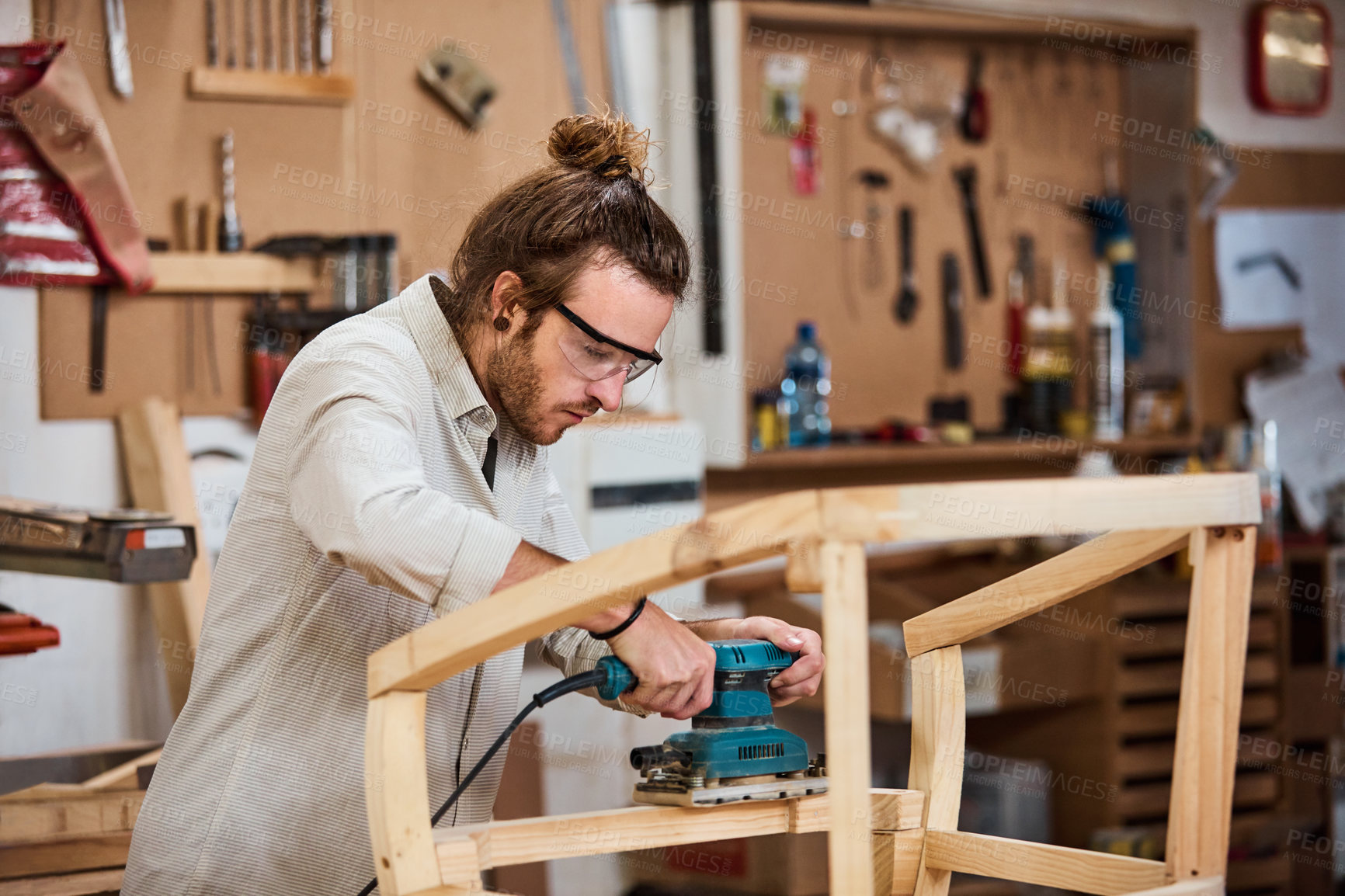 Buy stock photo Shot of a man working with wood in a furniture manufacturing workshop