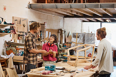 Buy stock photo Shot of three people working with wood in a furniture manufacturing workshop