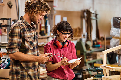 Buy stock photo Shot of two people working with wood in a furniture manufacturing workshop