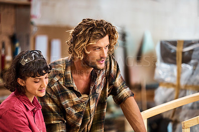 Buy stock photo Shot of two people working with wood in a furniture manufacturing workshop