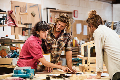 Buy stock photo Shot of three people working with wood in a furniture manufacturing workshop