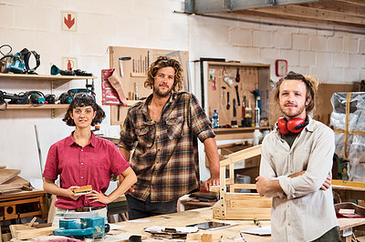 Buy stock photo Shot of three people working with wood in a furniture manufacturing workshop