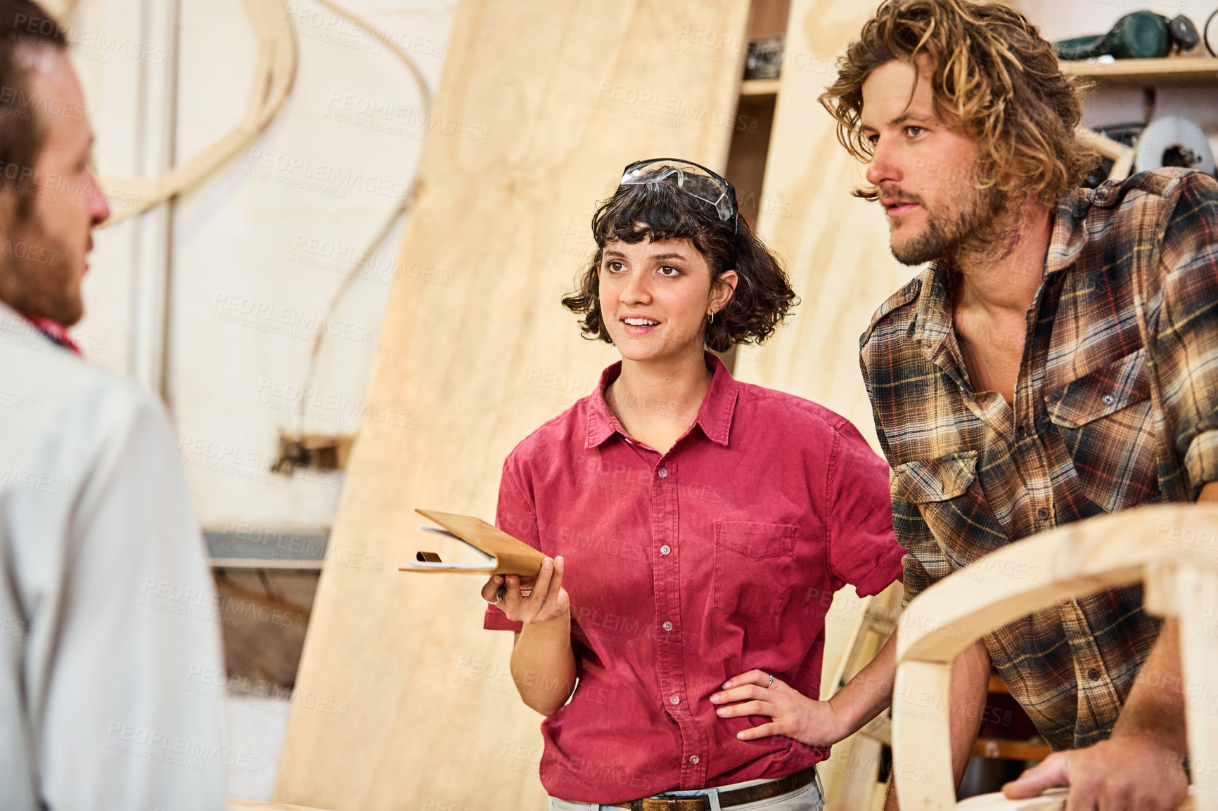 Buy stock photo Shot of three people working with wood in a furniture manufacturing workshop
