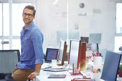 Buy stock photo Shot of a handsome young businessman in his office