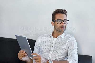 Buy stock photo Cropped shot of a handsome businessman using his digital tablet at work