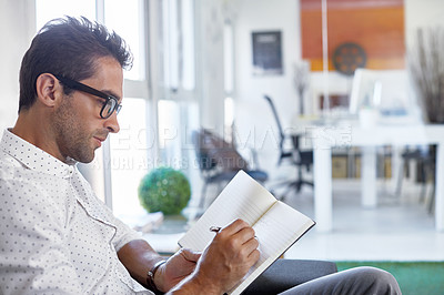 Buy stock photo Cropped shot of a businessman making notes in his diary