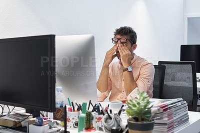 Buy stock photo Cropped shot of a businessman looking stressed while sitting at his desk