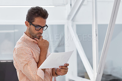 Buy stock photo Cropped shot of a businessman going over some paperwork