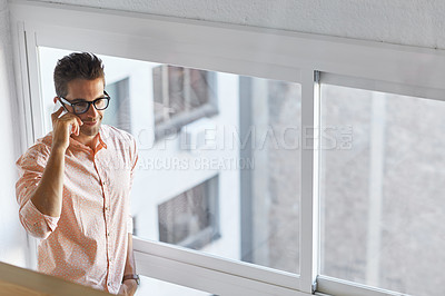 Buy stock photo Shot of a businessman using his cellphone in his office