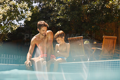 Buy stock photo Shot of a father and his son enjoying a day by the swimming pool
