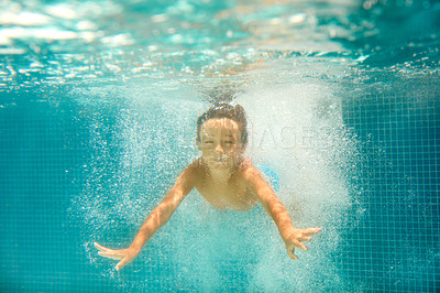 Buy stock photo Underwater shot of a little boy swimming in a pool