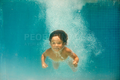 Buy stock photo Underwater shot of a little boy swimming in a pool