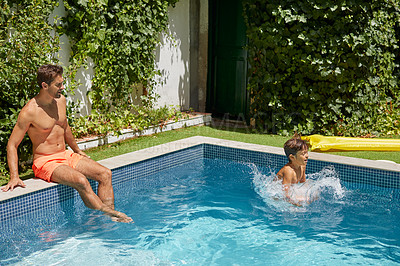 Buy stock photo Shot of a father and his son enjoying a day by the swimming pool