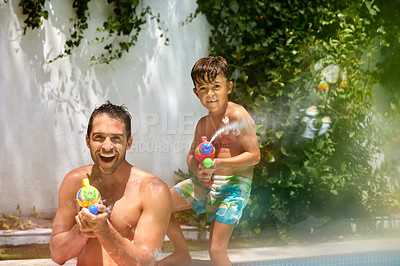 Buy stock photo Portrait of a father and his son playing with water guns at the swimming pool