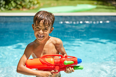 Buy stock photo Portrait of a little boy playing with a water gun in a swimming pool