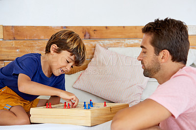 Buy stock photo Shot of a father and son playing a board game in the living room at home