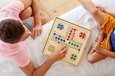 Buy stock photo High angle shot of a father and son playing a board game in the living room at home