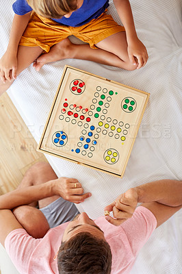 Buy stock photo High angle shot of a father and son playing a board game in the living room at home