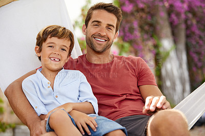 Buy stock photo Portrait of a father and son relaxing together on a hammock outside