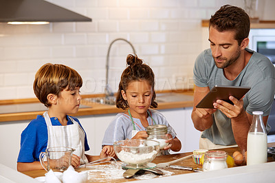Buy stock photo Cropped shot of a father helping his son and daughter bake at home