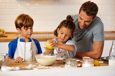 Buy stock photo Cropped shot of a father helping his son and daughter bake in the kitchen at home