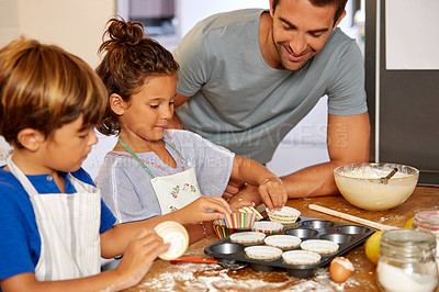Buy stock photo Cropped shot of a father helping his son and daughter bake in the kitchen at home