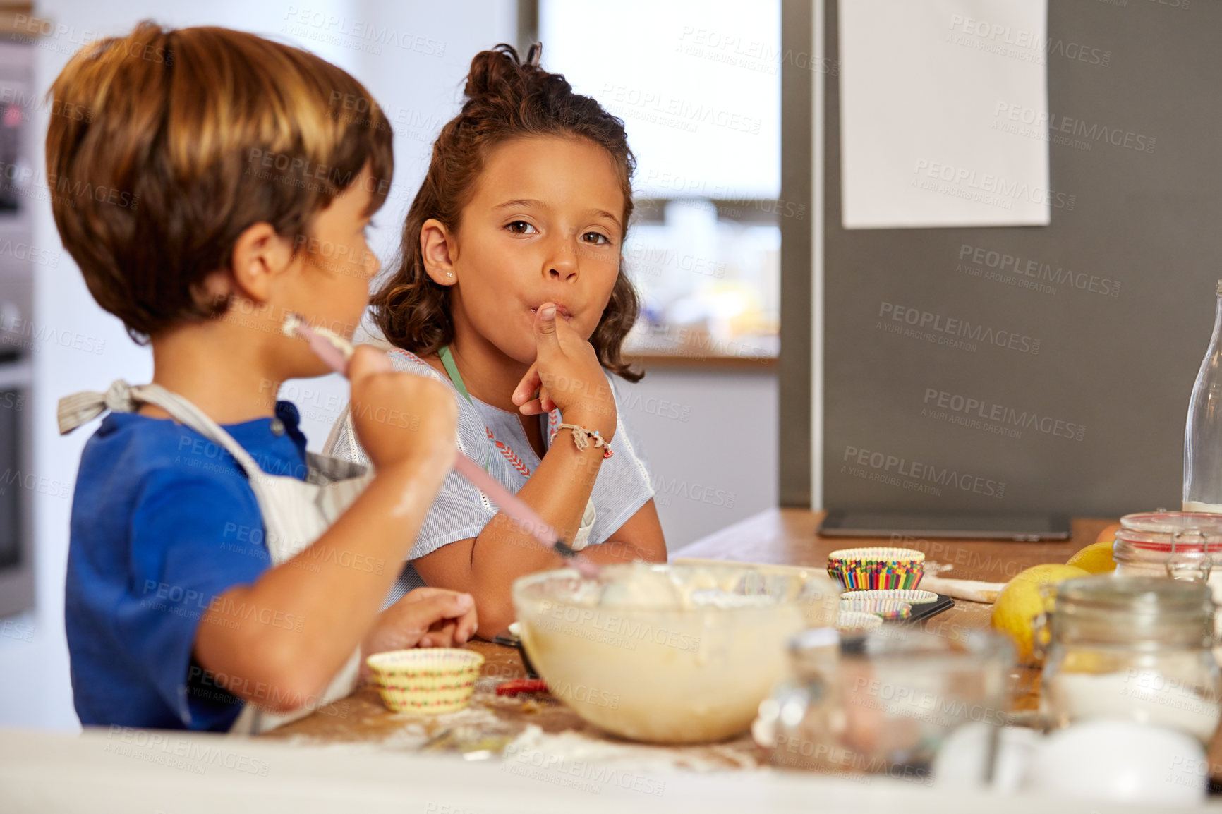 Buy stock photo Cropped shot of a brother and sister tasting batter in the kitchen at home