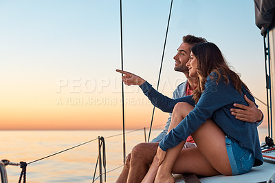 Buy stock photo Shot of a young couple enjoying a cruise out on the ocean