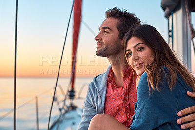 Buy stock photo Shot of a young couple enjoying a cruise out on the ocean