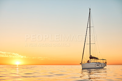 Buy stock photo Shot of a young couple going for an ocean cruise at sunset