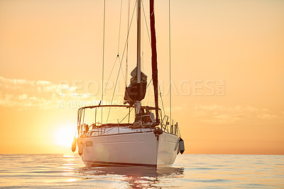 Buy stock photo Shot of a young couple going for an ocean cruise at sunset