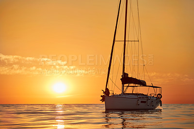 Buy stock photo Shot of a young couple going for an ocean cruise at sunset
