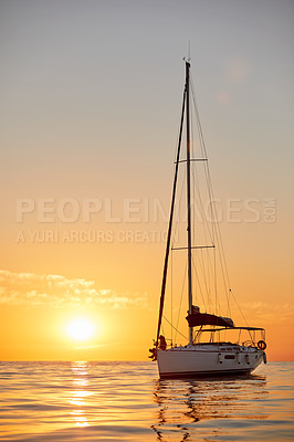 Buy stock photo Shot of a young couple going for an ocean cruise at sunset