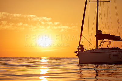 Buy stock photo Shot of a young couple going for an ocean cruise at sunset
