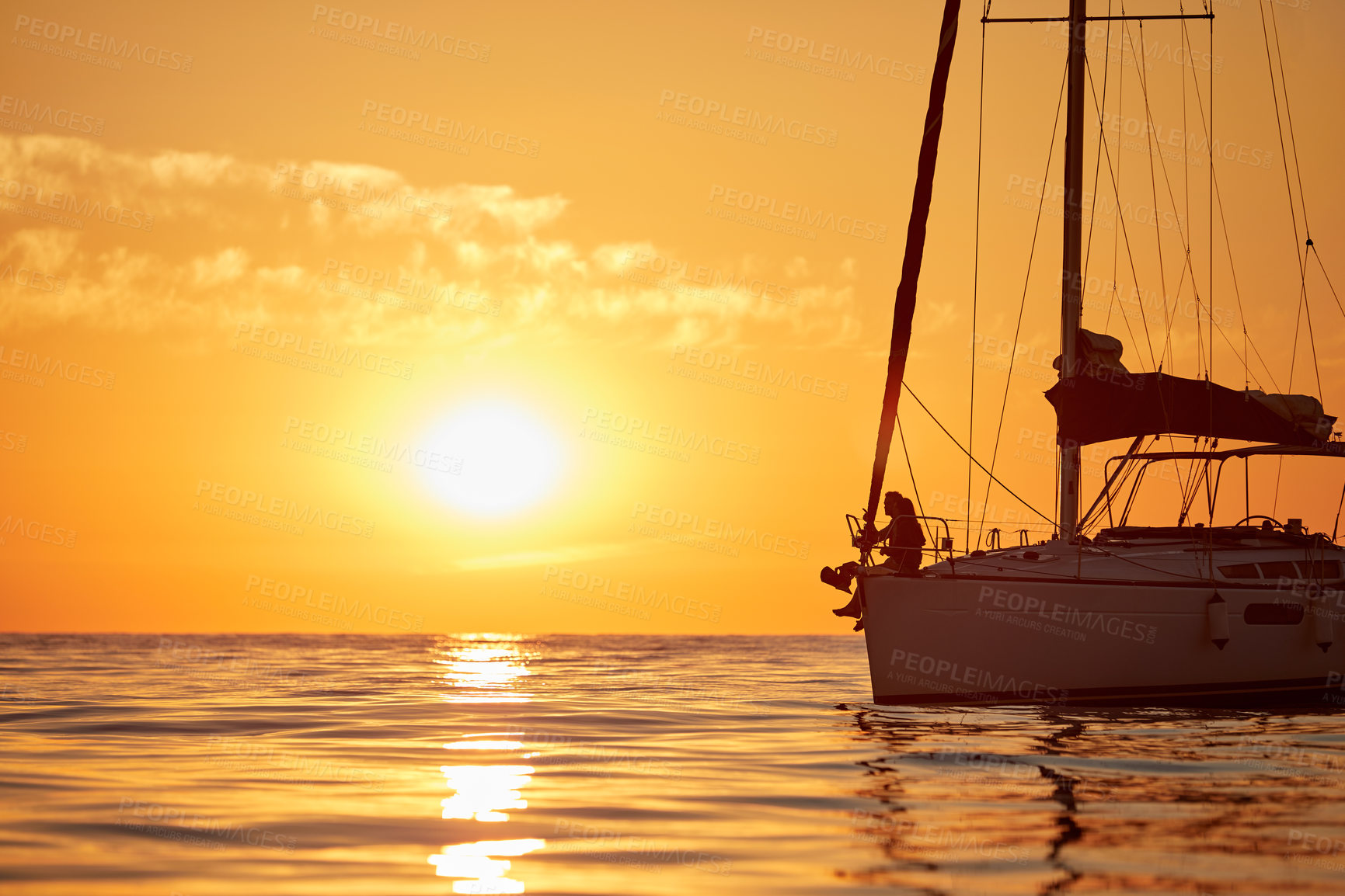 Buy stock photo Shot of a young couple going for an ocean cruise at sunset