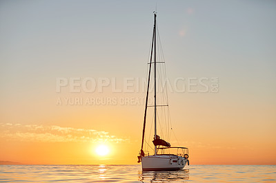 Buy stock photo Shot of a young couple going for an ocean cruise at sunset